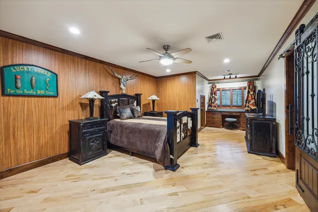 a large bedroom with a bed and wooden floor