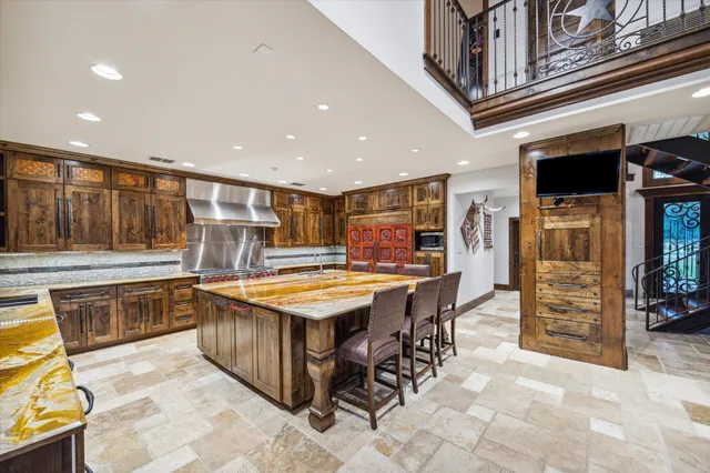 a kitchen with stainless steel appliances kitchen island granite countertop a table and chairs in it