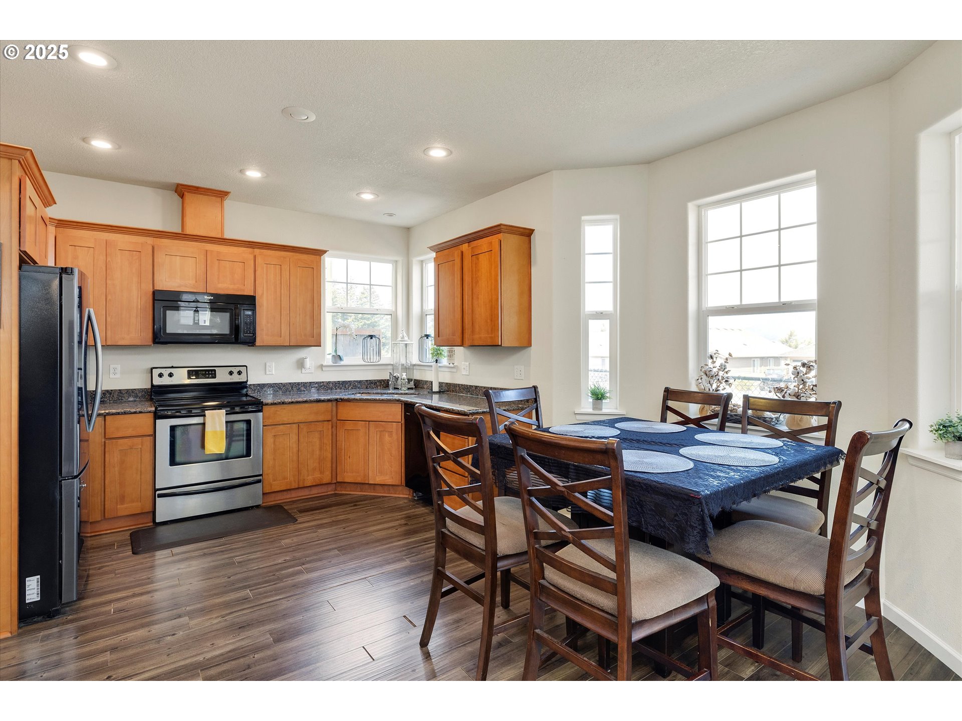 1153 Chinookan Drive Cascade Locks, OR 97014 - Photo 7 of 27 a kitchen with stainless steel appliances kitchen island granite countertop a table chairs a sink dishwasher a stove a microwave and cabinets