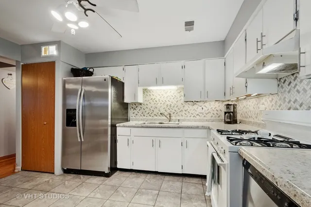 a kitchen with stainless steel appliances granite countertop a stove a refrigerator and a sink