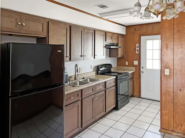 a kitchen with granite countertop a cabinets and a stove top oven