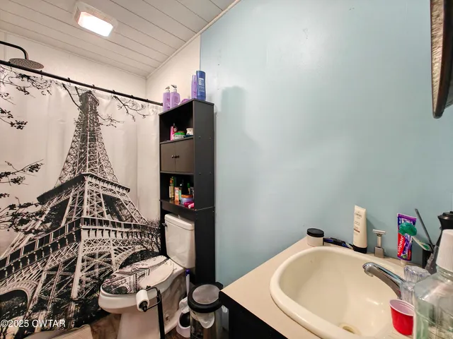 a bedroom with a bed a lamp and large window