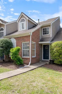 a view of a brick house with plants and large windows