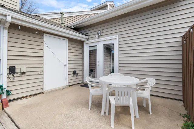 a view of a patio with table and chairs with wooden floor and fence