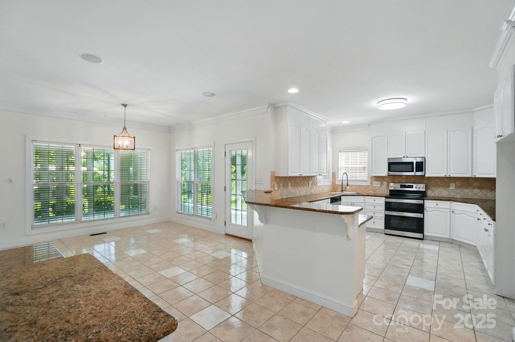 201 Limerick Drive Matthews, NC 28104 - Photo 12 of 34 a kitchen with a sink a counter top space appliances and cabinets