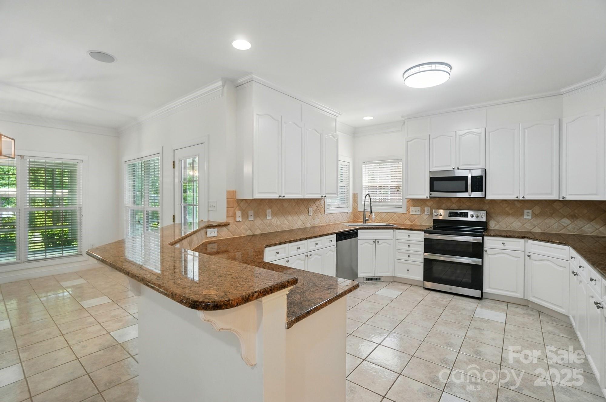 201 Limerick Drive Matthews, NC 28104 - Photo 14 of 34 a kitchen with granite countertop a stove sink and cabinets