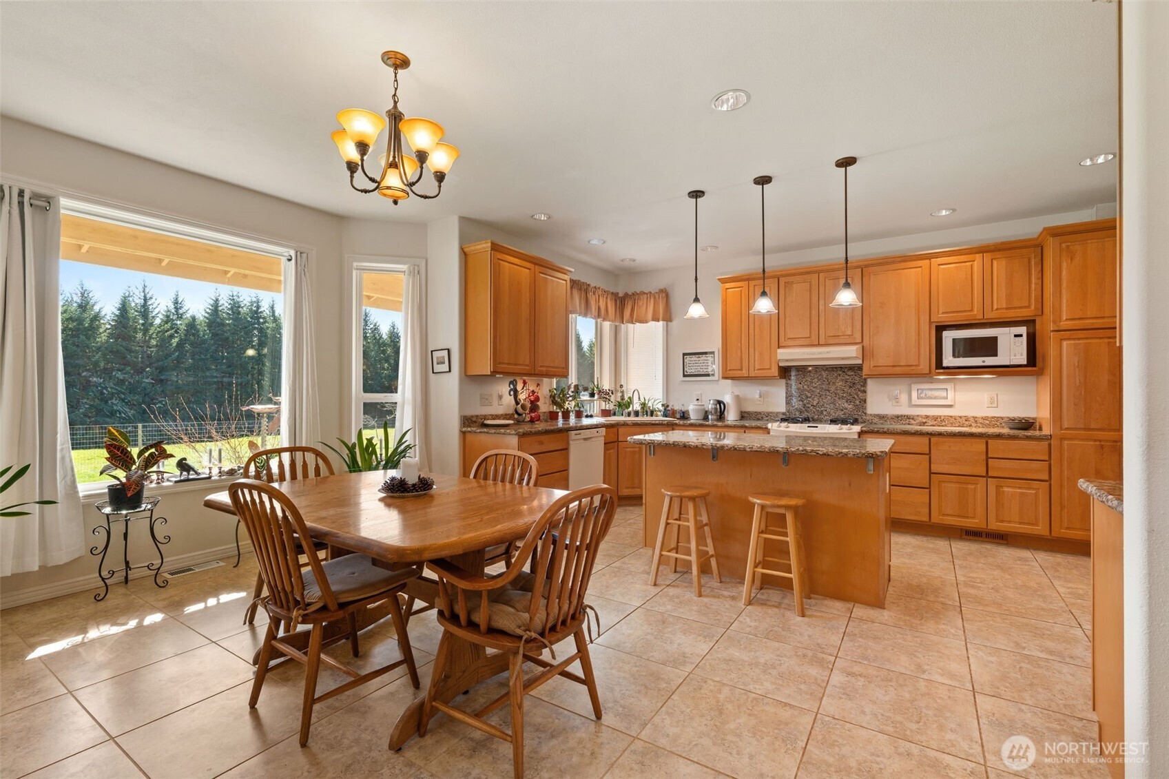 301 Russell Road Winlock, WA 98596 - Photo 6 of 40 a dining hall with stainless steel appliances kitchen island granite countertop a stove a kitchen island a dining table and chairs