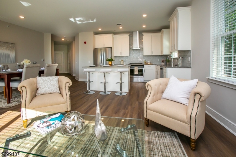 a living room with furniture and a kitchen