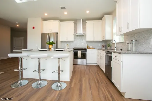 a large kitchen with stainless steel appliances granite countertop a sink a stove a dining table and chairs