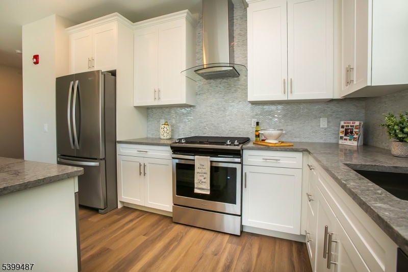 74 Passaic Avenue, Unit 107 Fairfield, NJ 07004 - Photo 4 of 13 a kitchen with stainless steel appliances white cabinets and a granite counter tops