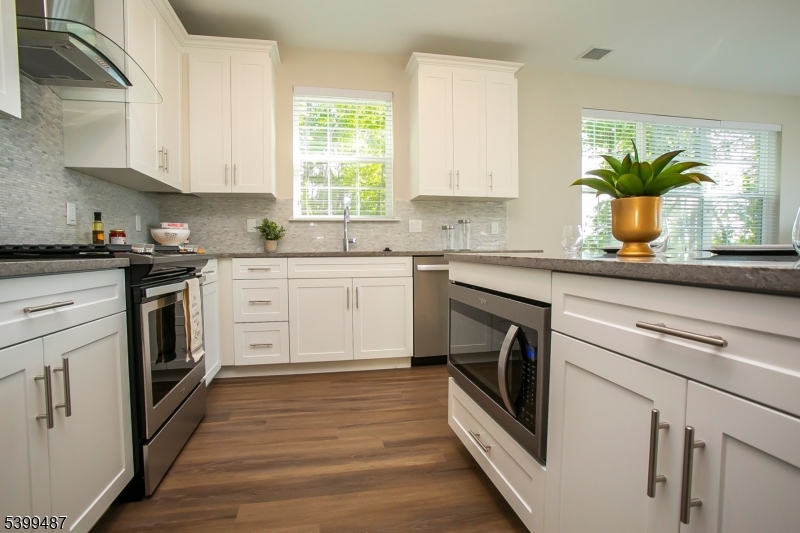 74 Passaic Avenue, Unit 107 Fairfield, NJ 07004 - Photo 5 of 13 a kitchen with stainless steel appliances granite countertop white cabinets a sink and a dishwasher