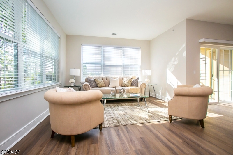 74 Passaic Avenue, Unit 107 Fairfield, NJ 07004 - Photo 8 of 13 a living room with furniture and a large window