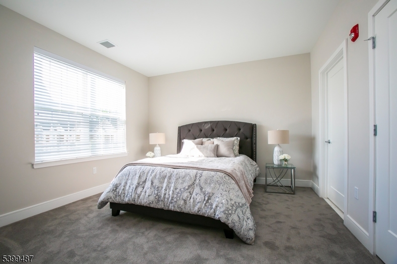 74 Passaic Avenue, Unit 107 Fairfield, NJ 07004 - Photo 9 of 13 a bedroom with a bed and a window