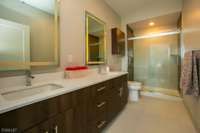 a bathroom with a granite countertop sink toilet mirror and shower