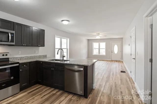 a kitchen with sink a window and wooden floor
