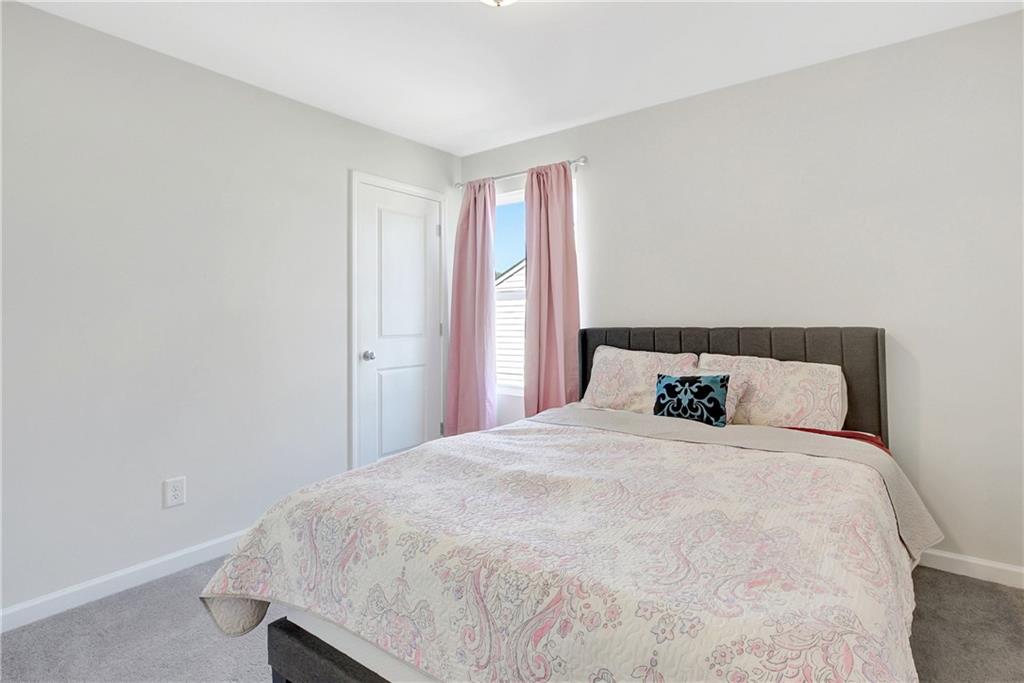 130 Catalpa Road Milner, GA 30257 - Photo 18 of 23 a large bed sitting in a bedroom next to a window