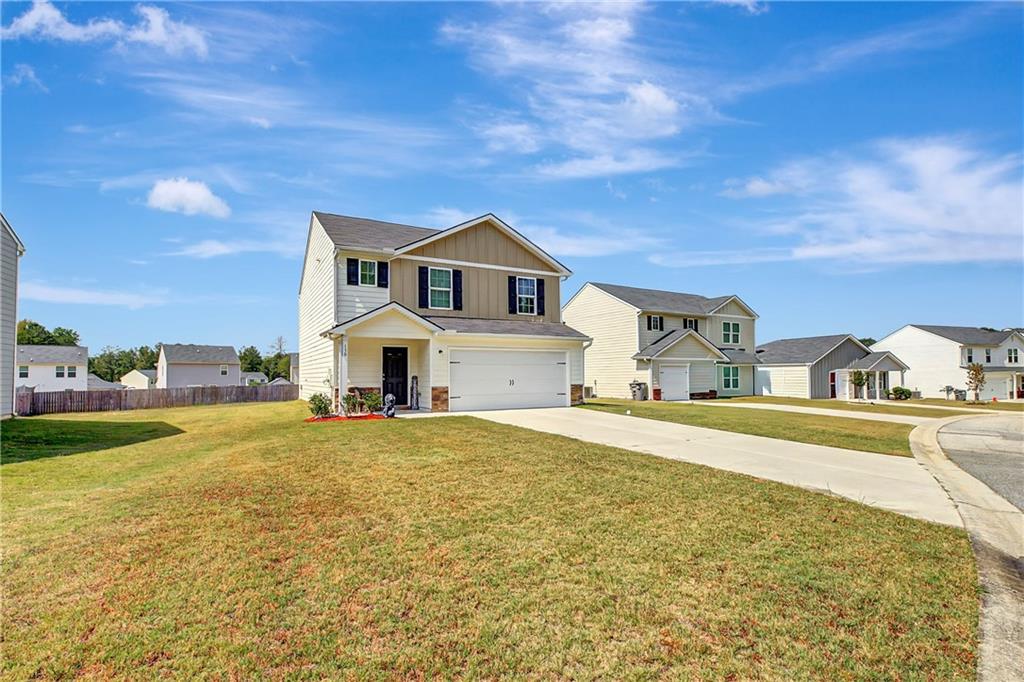 130 Catalpa Road Milner, GA 30257 - Photo 3 of 23 a front view of a house with a yard and garage