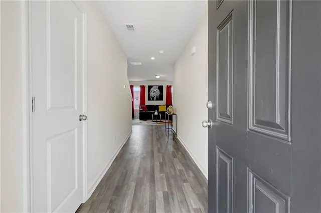 a view of a hallway with wooden floor and staircase