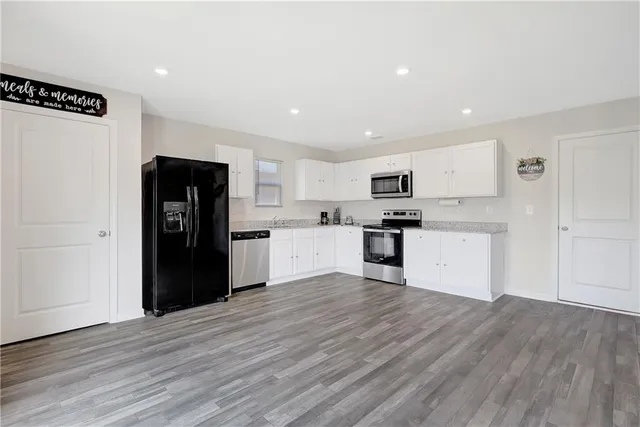 a kitchen with granite countertop white cabinets and stainless steel appliances