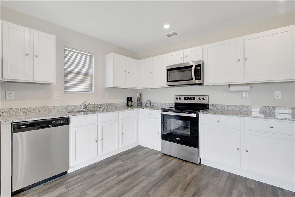 130 Catalpa Road Milner, GA 30257 - Photo 9 of 23 a kitchen with granite countertop white cabinets and stainless steel appliances