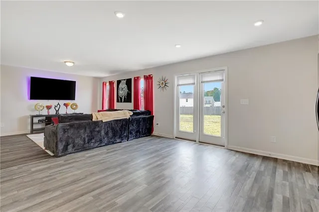 a view of an empty room with a kitchen and a window