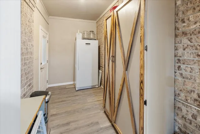 a view of a hallway with wooden floor and entryway