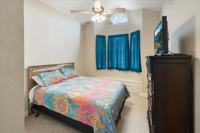 a bedroom with a bed and a flat tv screen on dresser