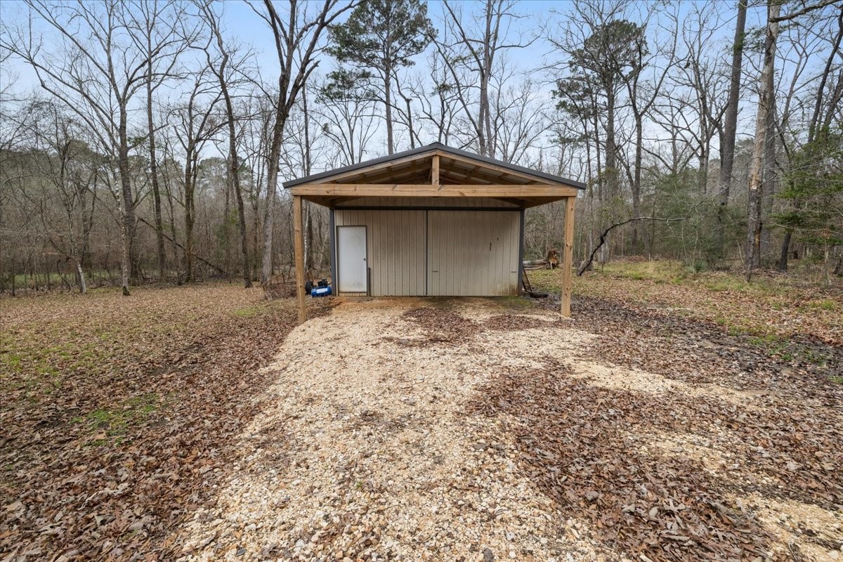 755 Mallard Street Hemphill, TX 75948 - Photo 26 of 27 a backyard of a house with large trees