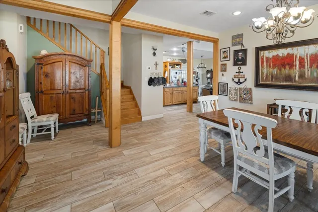 a dining room with furniture a chandelier and wooden floor