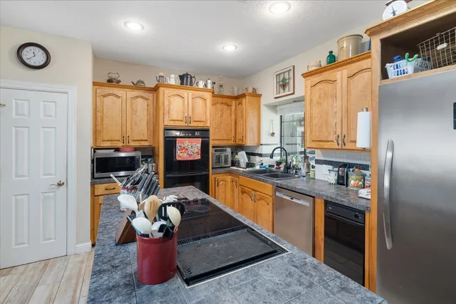 a kitchen with stainless steel appliances granite countertop a refrigerator and a sink