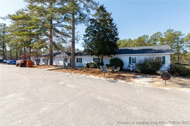 a view of a tennis ground with large trees