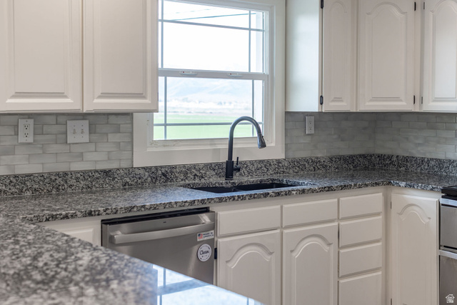 4155 Johnson Road Nibley, UT 84321 - Photo 10 of 71 Kitchen with white cabinets, stainless steel dishwasher, dark stone countertops, backsplash, and plenty of natural light