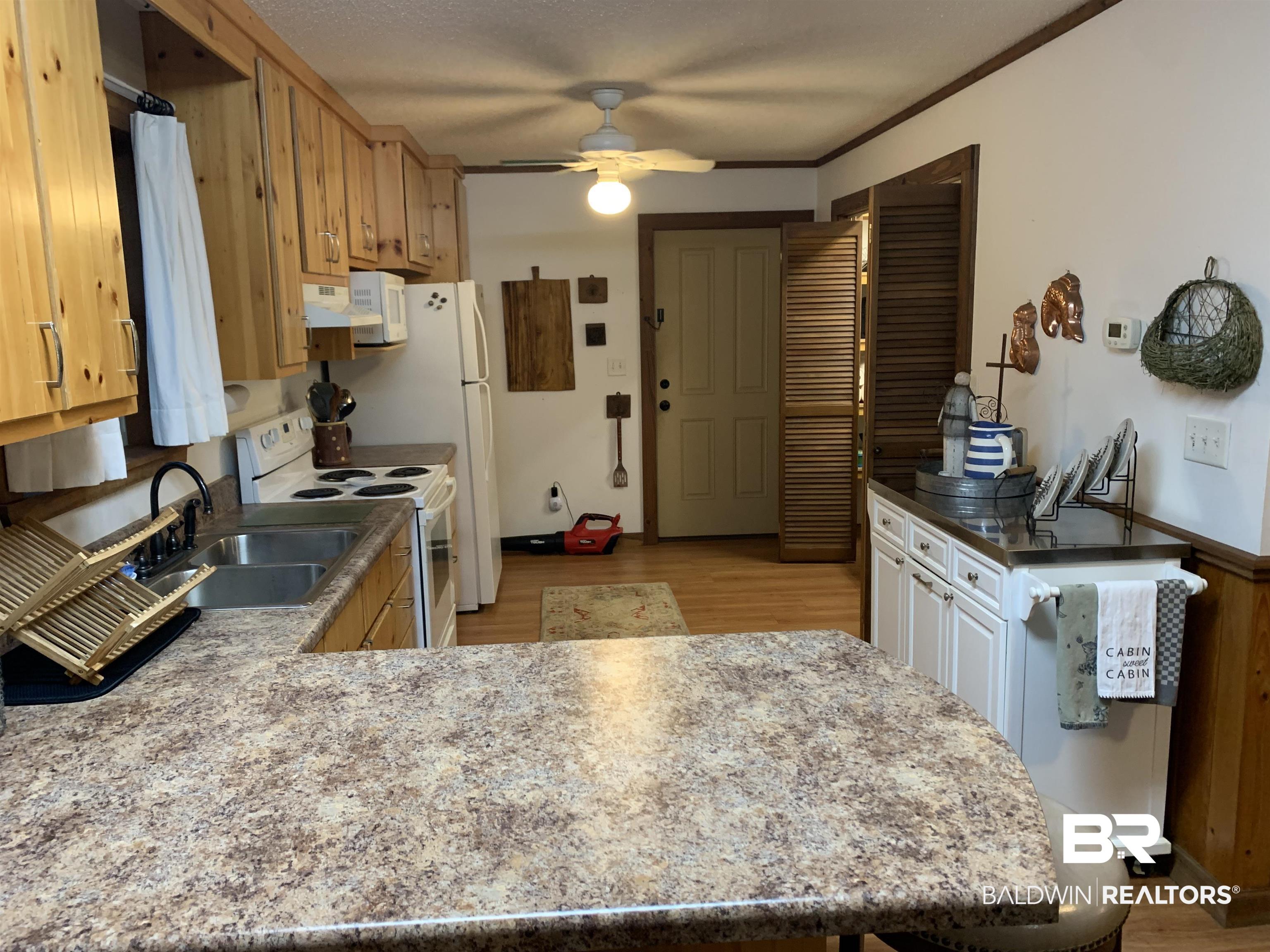 465 Rock Creek Road Wing, AL 36483 - Photo 6 of 15 Kitchen featuring sink, kitchen peninsula, white range with electric stovetop, light hardwood / wood-style floors, and ceiling fan