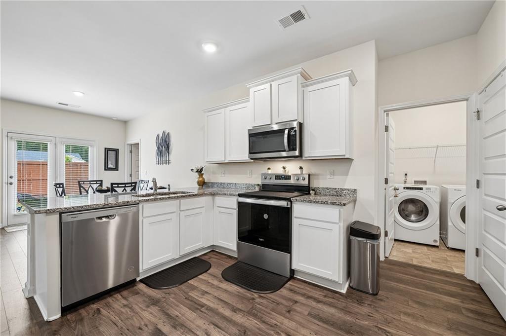 8592 Seabiscuit Road Lithonia, GA 30058 - Photo 7 of 25 a kitchen with a sink a stove and cabinets