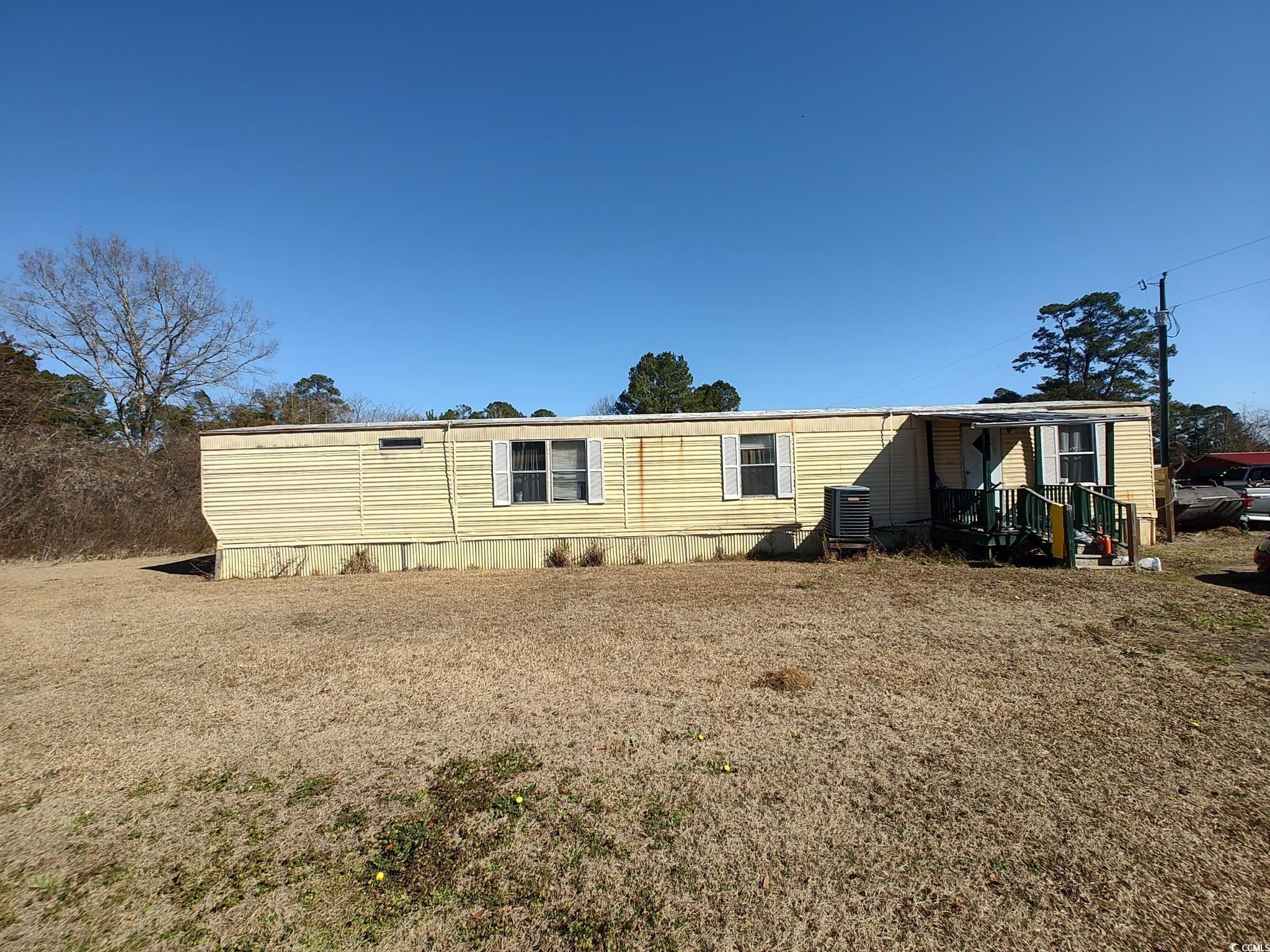 Rear view of property with a yard and central air condition unit