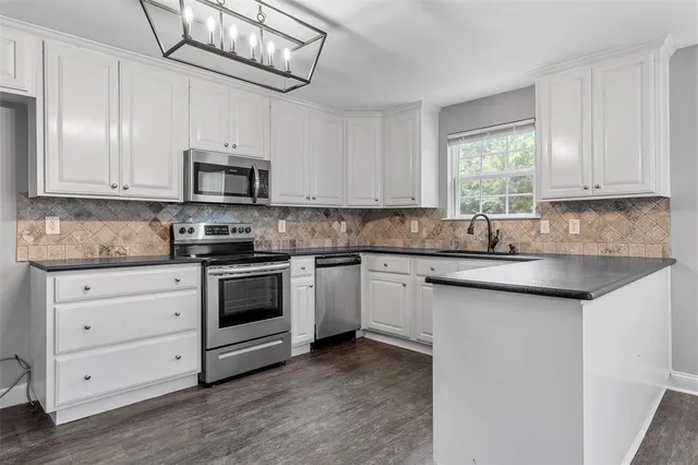 a kitchen with stainless steel appliances granite countertop a sink a stove and cabinets