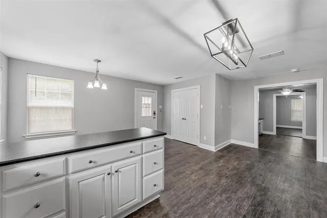 a view of a kitchen with cabinets and wooden floor