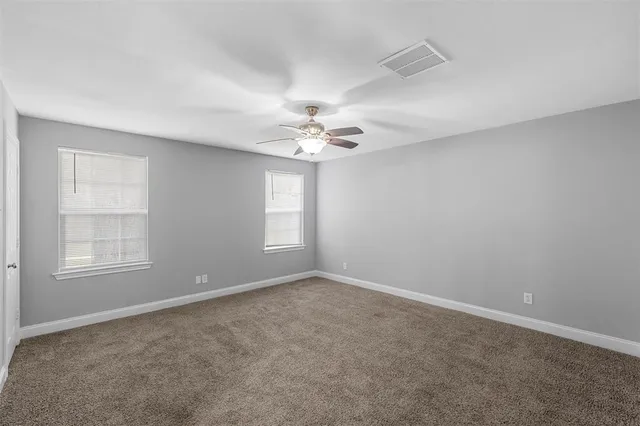 an empty room with a window and a ceiling fan