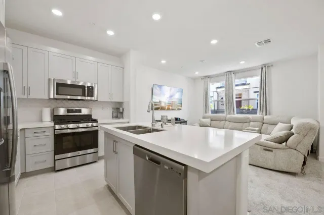 a kitchen with a sink and white cabinets