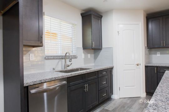 1308 Sims Street Ridgecrest, CA 93555 - Photo 5 of 12 a kitchen with stainless steel appliances granite countertop a sink stove and cabinets