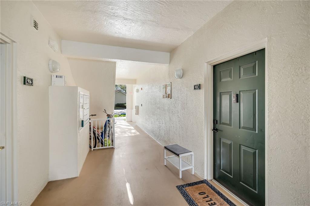 4620 St Croix Lane, Unit 918 Naples, FL 34109 - Photo 21 of 43 a hallway with wooden floor white walls and stairs