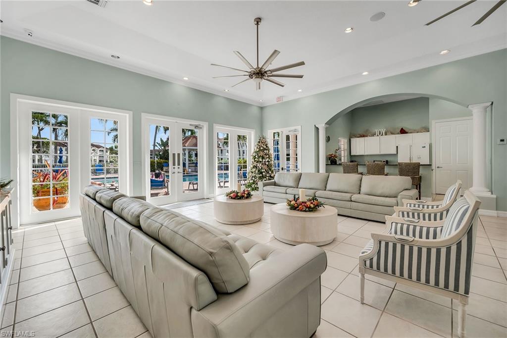 4620 St Croix Lane, Unit 918 Naples, FL 34109 - Photo 33 of 43 a large living room with stainless steel appliances furniture a chandelier and a large window