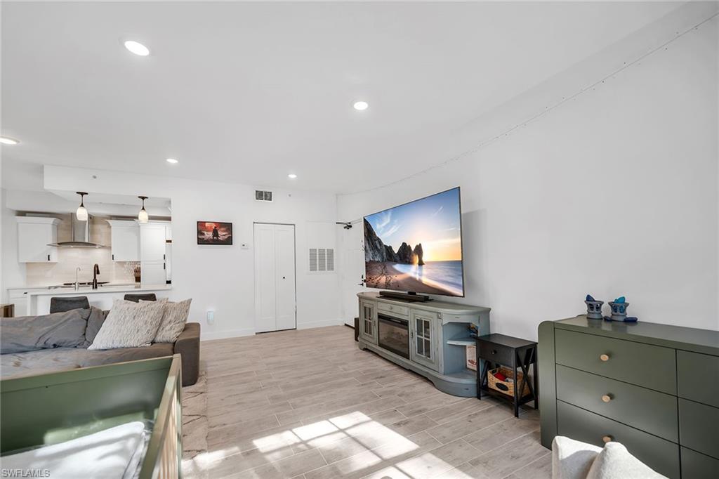 4620 St Croix Lane, Unit 918 Naples, FL 34109 - Photo 4 of 43 a living room with kitchen furniture and a flat screen tv