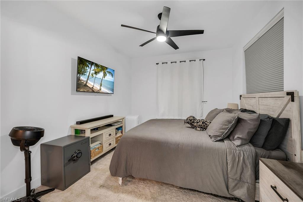 4620 St Croix Lane, Unit 918 Naples, FL 34109 - Photo 10 of 43 a bedroom with a bed and a chandelier