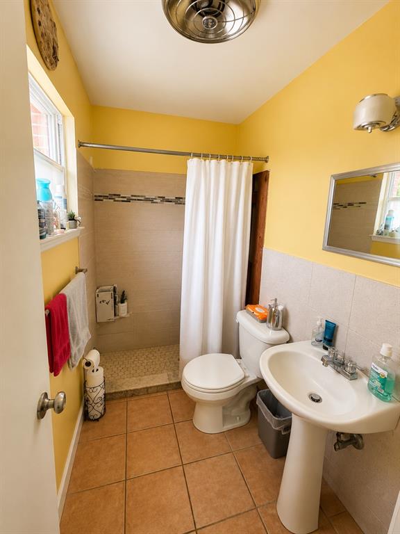 4357 Chestnut Drive Mesquite, TX 75150 - Photo 7 of 9 Bathroom featuring a walk-in shower with tiled walls and a mosaic accent band, a pedestal sink, and tiled flooring