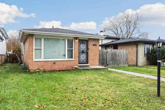 a view of a house with a yard and large tree