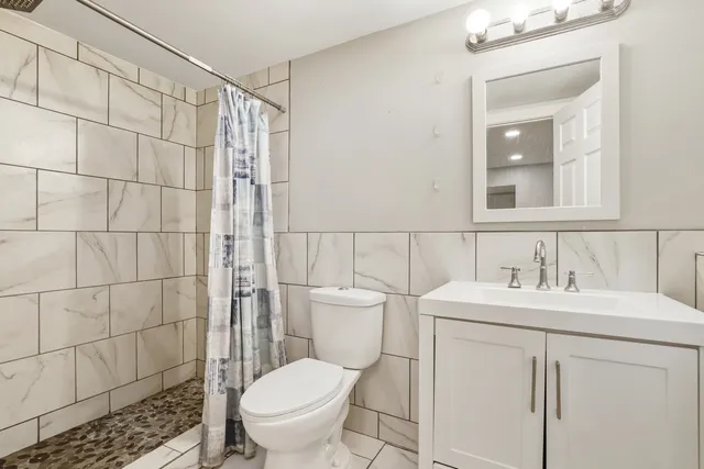 a bathroom with a toilet sink shower and mirror