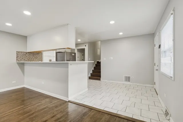 a view of a kitchen with furniture and wooden floor
