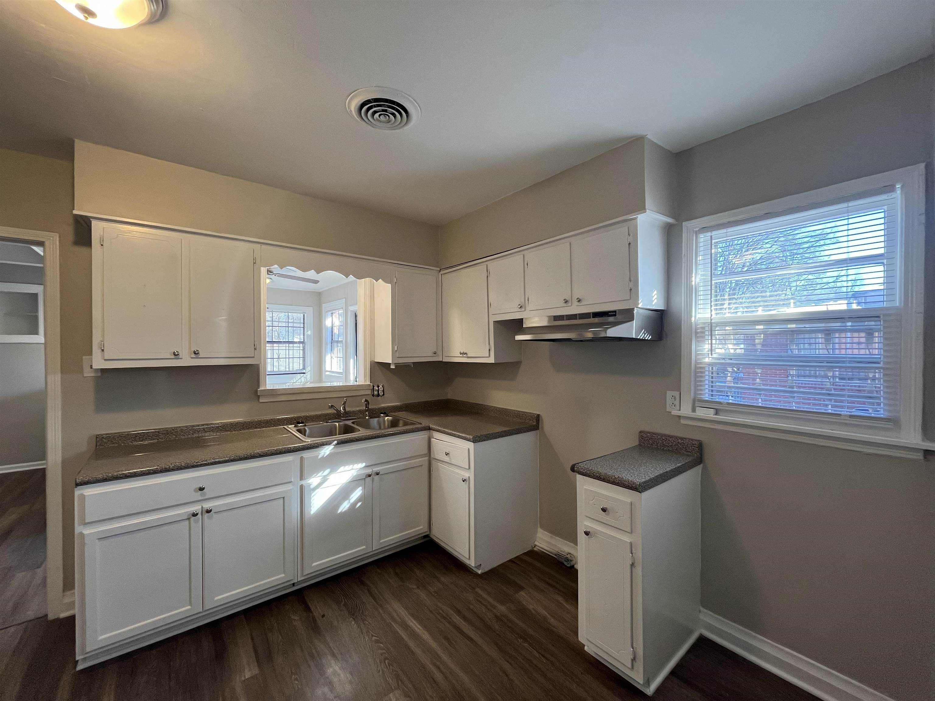 1362 Springdale Street Memphis, TN 38108 - Photo 4 of 16 a kitchen with granite countertop white cabinets and white appliances