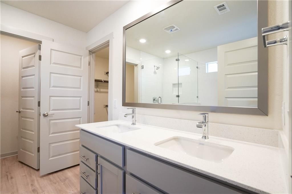 2341 Gabriels Horn Road Leander, TX 78641 - Photo 13 of 20 Bathroom featuring double vanity, a stall shower, light wood-style floors, a walk in closet, and recessed lighting
